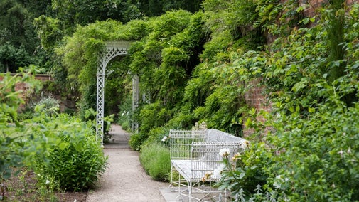 Hare Hill Walled Garden in the summer, white bench just off the path